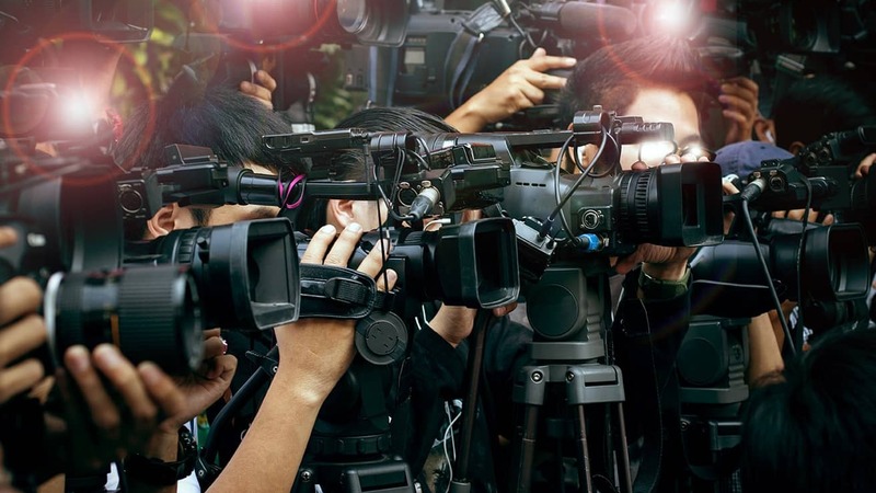 Journalists with cameras and microphones
